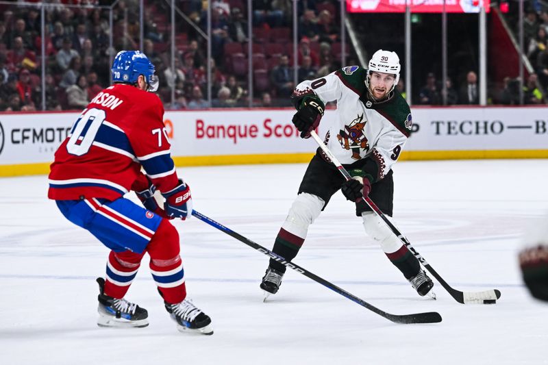 Feb 27, 2024; Montreal, Quebec, CAN; Arizona Coyotes defenseman J.J. Moser (90) plays the puck against Montreal Canadiens left wing Tanner Pearson (70) during the third period at Bell Centre. Mandatory Credit: David Kirouac-USA TODAY Sports