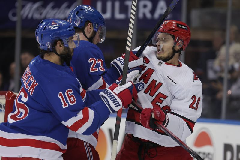 May 13, 2024; New York, New York, USA; Carolina Hurricanes center Sebastian Aho (20) skates against New York Rangers defenseman Adam Fox (23) and center Vincent Trocheck (16) during the first period of game five of the second round of the 2024 Stanley Cup Playoffs at Madison Square Garden. Mandatory Credit: Brad Penner-USA TODAY Sports