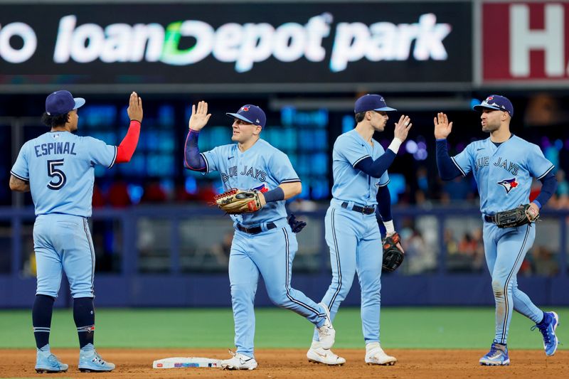 Jun 21, 2023; Miami, Florida, USA; Toronto Blue Jays second baseman Santiago Espinal (5), left fielder Daulton Varsho (25), second baseman Cavan Biggio (8), and center fielder Kevin Kiermaier (39) celebrate after winning the game against the Miami Marlins at loanDepot Park. Mandatory Credit: Sam Navarro-USA TODAY Sports