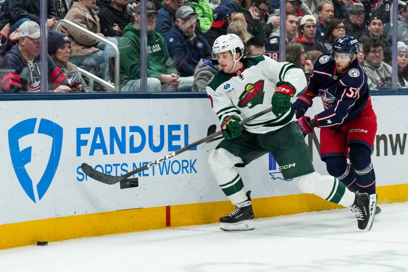Dec 18, 2025; Columbus, Ohio, USA;  Minnesota Wild defenseman Brock Faber (7) skates for the puck against Columbus Blue Jackets right wing Yegor Chinakhov (59) in the third period at Nationwide Arena. Mandatory Credit: Aaron Doster-Imagn Images