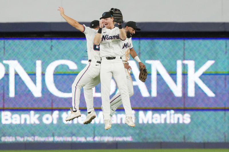 Aug 20, 2025; Miami, Florida, USA;  Miami Marlins outfielders Jakob Marsee, left, Joey Wiemer, center, and Derek Hill celebrate a victory over the St. Louis Cardinals at loanDepot Park. Mandatory Credit: Jim Rassol-Imagn Images