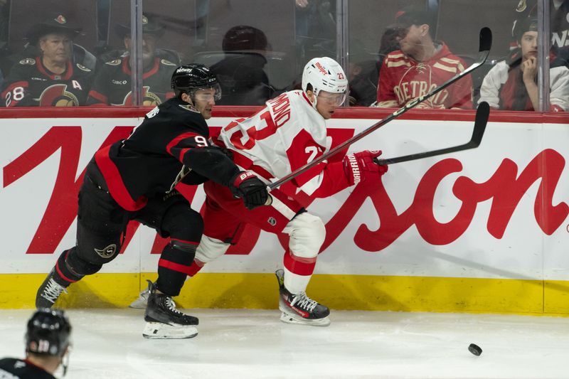 Dec 5, 2024; Ottawa, Ontario, CAN;  Ottawa Senators center Josh Norris and Detroit Red Wings left wing Lucas Raymond (23) chase the puck in the third period at the Canadian Tire Centre. Mandatory Credit: Marc DesRosiers-Imagn Images