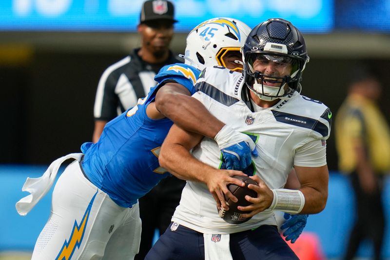 Seattle Seahawks quarterback Sam Howell, right, is pressured by Los Angeles Chargers linebacker Tuli Tuipulotu during the first half of a preseason NFL football game in Inglewood, Calif., Saturday, Aug. 10, 2024. (AP Photo/Gregory Bull)