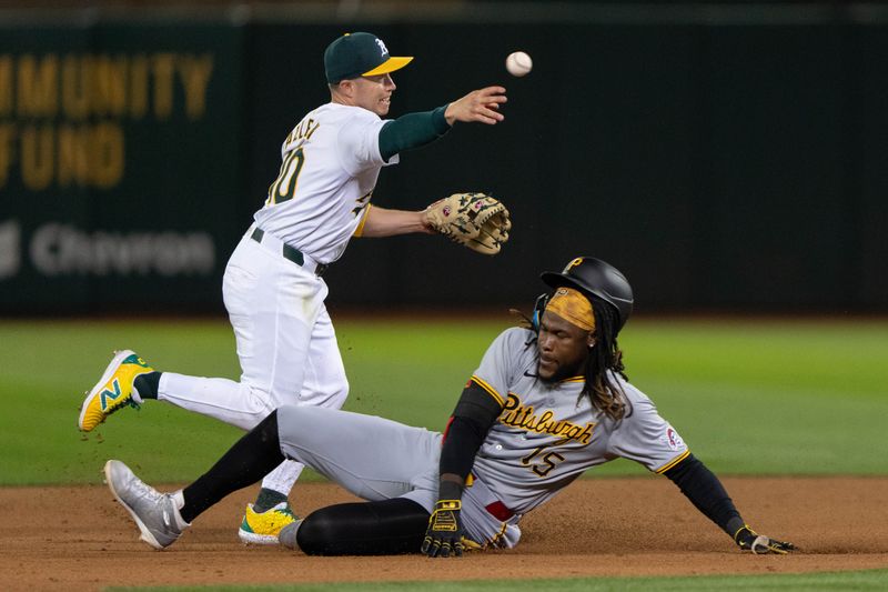 Apr 29, 2024; Oakland, California, USA; Oakland Athletics shortstop Nick Allen (10) throws the ball to first after a force tag on Pittsburgh Pirates shortstop Oneil Cruz (15) during the ninth inning at Oakland-Alameda County Coliseum. Mandatory Credit: Stan Szeto-USA TODAY Sports