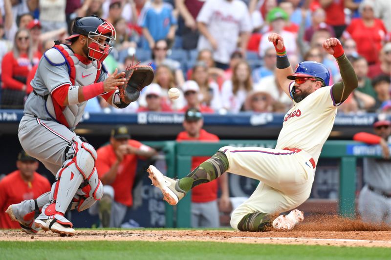 May 19, 2024; Philadelphia, Pennsylvania, USA; Philadelphia Phillies designated hitter Kyle Schwarber (12) slides safely into home ahead of tag by Washington Nationals catcher Keibert Ruiz (20) during the fifth inning at Citizens Bank Park. Mandatory Credit: Eric Hartline-USA TODAY Sports