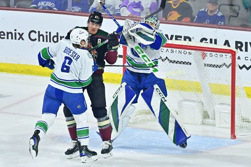 Apr 3, 2024; Tempe, Arizona, USA; Vancouver Canucks right wing Brock Boeser (6) pushes Arizona Coyotes left wing Lawson Crouse (67) into goaltender Arturs Silovs (31)in the first period at Mullett Arena. Mandatory Credit: Matt Kartozian-USA TODAY Sports