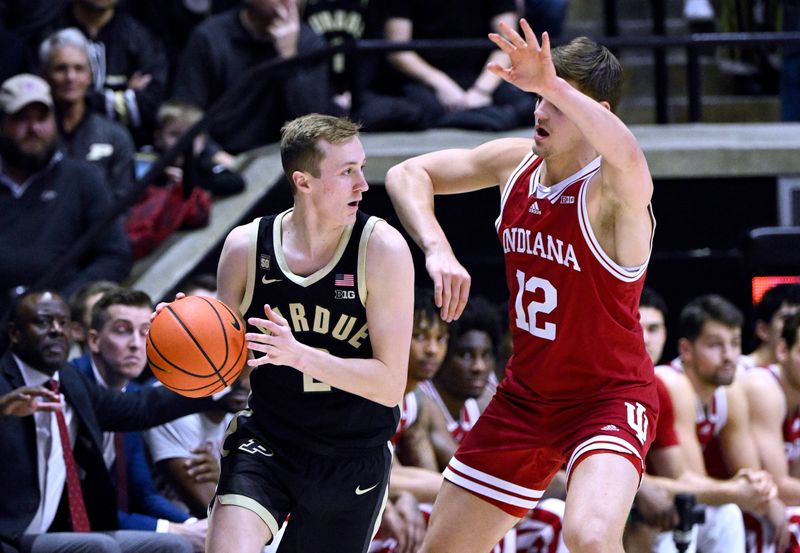 Feb 25, 2023; West Lafayette, Indiana, USA;  Purdue Boilermakers guard Fletcher Loyer (2) controls the ball against Indiana Hoosiers forward Miller Kopp (12) during the first half at Mackey Arena. Mandatory Credit: Marc Lebryk-USA TODAY Sports