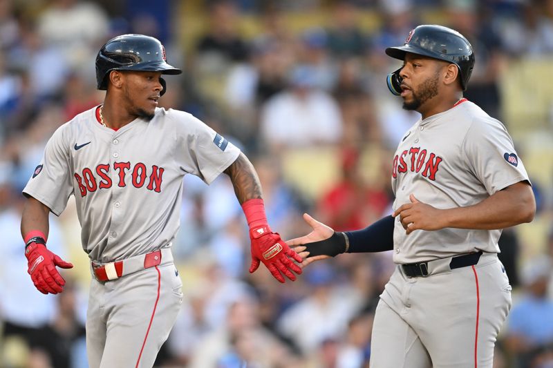 Jul 21, 2024; Los Angeles, California, USA; Boston Red Sox outfielder Ceddanne Rafaela (43) and first base Dominic Smith (2) celebrate after scoring against the Los Angeles Dodgers during the ninth inning at Dodger Stadium. Mandatory Credit: Jonathan Hui-USA TODAY Sports