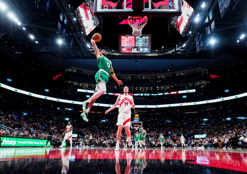 TORONTO, ON - OCTOBER 15: Jayson Tatum #0 of the Boston Celtics dunks past Jakob Poeltl #19 of the Toronto Raptors during the second half of their preseason basketball game at the Scotiabank Arena on October 15, 2024 in Toronto, Ontario, Canada. NOTE TO USER: User expressly acknowledges and agrees that, by downloading and/or using this Photograph, user is consenting to the terms and conditions of the Getty Images License Agreement. (Photo by Mark Blinch/Getty Images)