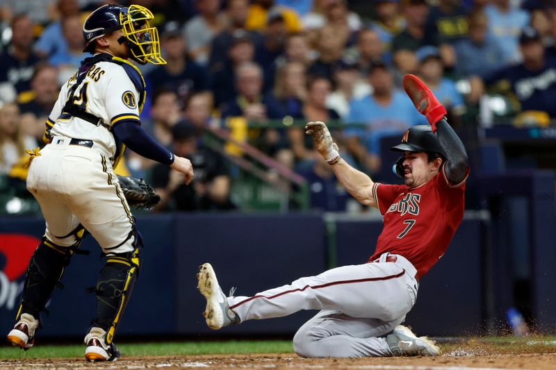 Oct 4, 2023; Milwaukee, Wisconsin, USA; Arizona Diamondbacks left fielder Corbin Carroll (7) slides home to score in the sixth inning against Milwaukee Brewers catcher William Contreras (24) during game two of the Wildcard series for the 2023 MLB playoffs at American Family Field. Mandatory Credit: Kamil Krzaczynski-USA TODAY Sports