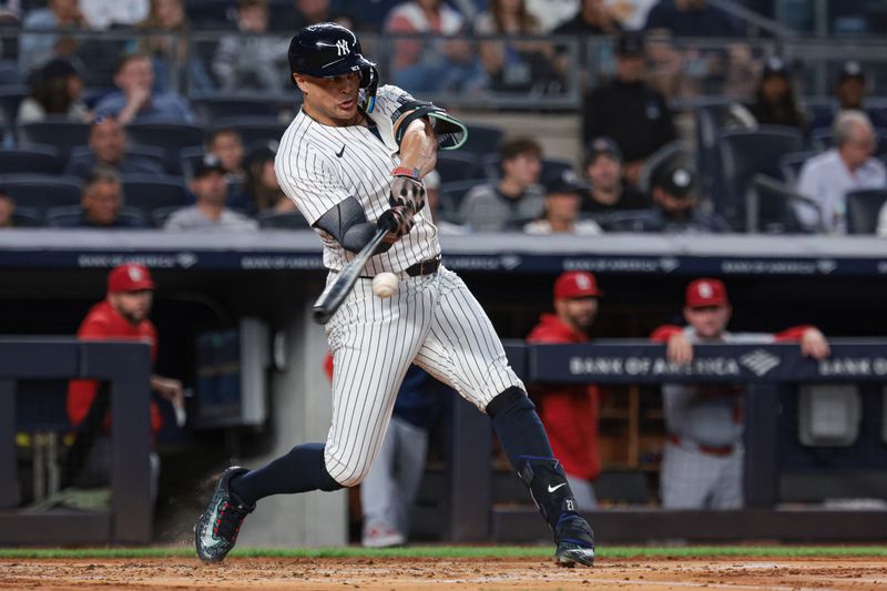 Aug 30, 2024; Bronx, New York, USA; New York Yankees designated hitter Giancarlo Stanton (27) doubles during the second inning against the St. Louis Cardinals at Yankee Stadium. Mandatory Credit: Vincent Carchietta-USA TODAY Sports