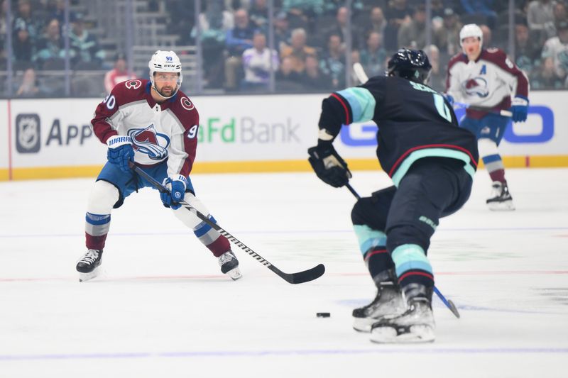 Nov 13, 2023; Seattle, Washington, USA; Colorado Avalanche left wing Tomas Tatar (90) plays the puck while defended by Seattle Kraken defenseman Justin Schultz (4) during the first period at Climate Pledge Arena. Mandatory Credit: Steven Bisig-USA TODAY Sports