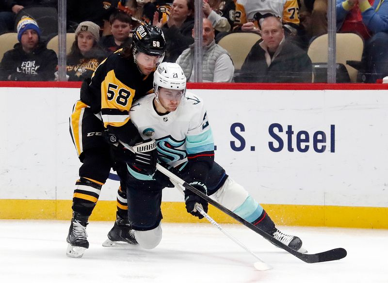 Jan 15, 2024; Pittsburgh, Pennsylvania, USA; Pittsburgh Penguins defenseman Kris Letang (58) defends Seattle Kraken center Alex Wennberg (21) during the second period at PPG Paints Arena. Mandatory Credit: Charles LeClaire-USA TODAY Sports