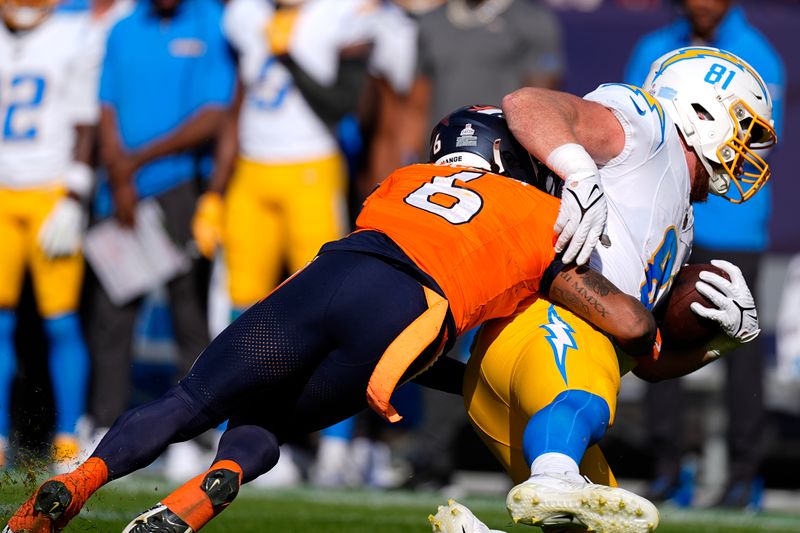 Los Angeles Chargers tight end Will Dissly (81) is tackled by Denver Broncos safety P.J. Locke (6) during the first half of an NFL football game, Sunday, Oct. 13, 2024, in Denver. (AP Photo/David Zalubowski)