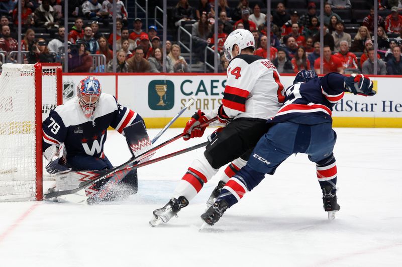 Feb 20, 2024; Washington, District of Columbia, USA; Washington Capitals goaltender Charlie Lindgren (79) makes a save on New Jersey Devils right wing Nathan Bastian (14) as Capitals defenseman Nick Jensen (3) defends in the first period at Capital One Arena. Mandatory Credit: Geoff Burke-USA TODAY Sports