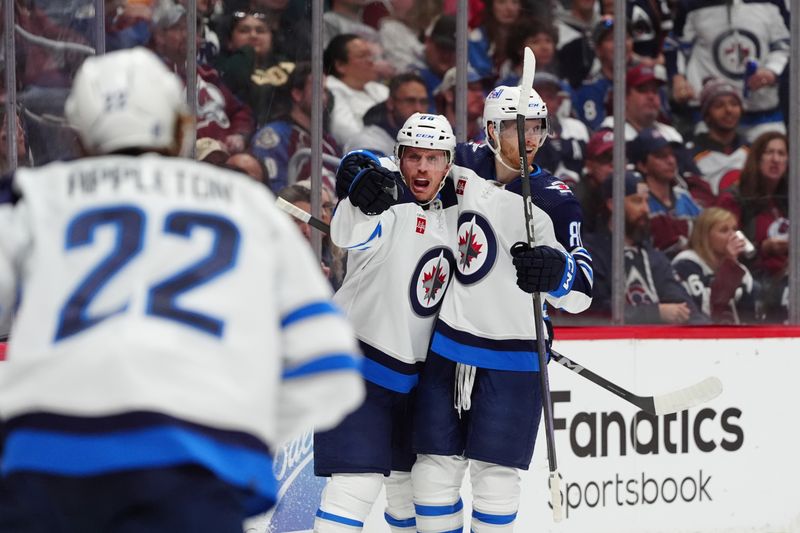 Apr 28, 2024; Denver, Colorado, USA; Winnipeg Jets defenseman Nate Schmidt (88) and left wing Kyle Connor (81) celebrate a goal during the first period against the Colorado Avalanche in game four of the first round of the 2024 Stanley Cup Playoffs at Ball Arena. Mandatory Credit: Ron Chenoy-USA TODAY Sports