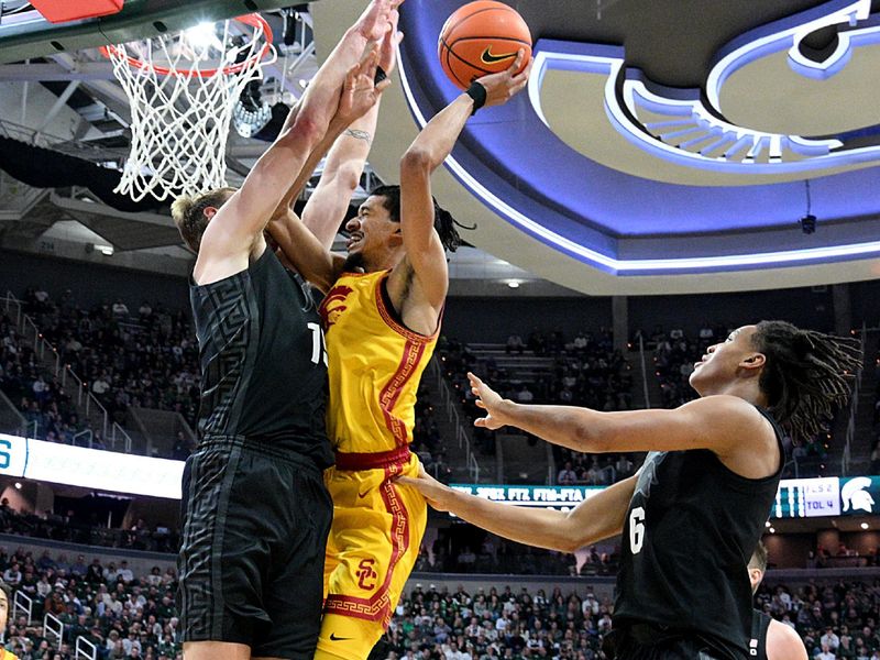 Jan 5, 2026; East Lansing, Michigan, USA;  Southern California Trojans forward Chad Baker-Mazara (4) takes the ball up against Michigan State Spartans center Carson Cooper (15) during the first half at Jack Breslin Student Events Center. Mandatory Credit: Dale Young-Imagn Images