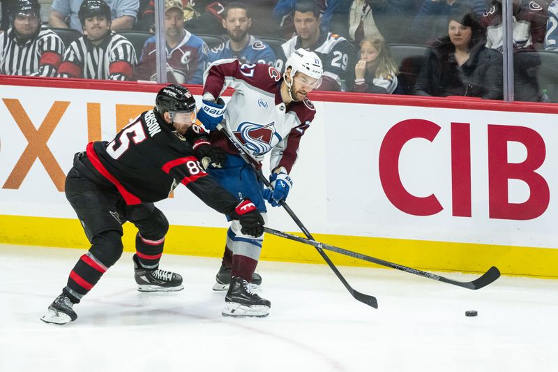 Mar 20, 2025; Ottawa, Ontario, CAN; Ottawa Senators defenseman Jake Sanderson (85) battles with  Colorado Avalanche left wing Jonathan Droin (27) for control of the puck in the third period at the Canadian Tire Centre. Mandatory Credit: Marc DesRosiers-Imagn Images