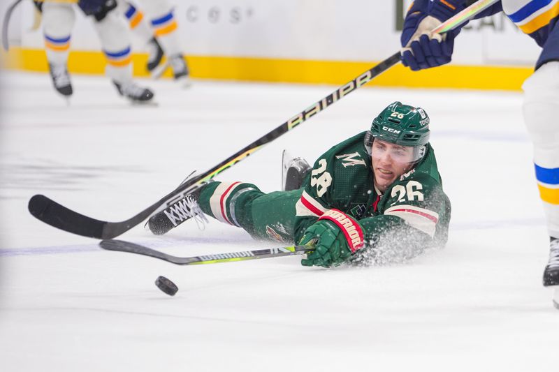 Nov 28, 2023; Saint Paul, Minnesota, USA; Minnesota Wild center Connor Dewar (26) reaches for the puck against the St. Louis Blues in the second period at Xcel Energy Center. Mandatory Credit: Brad Rempel-USA TODAY Sports