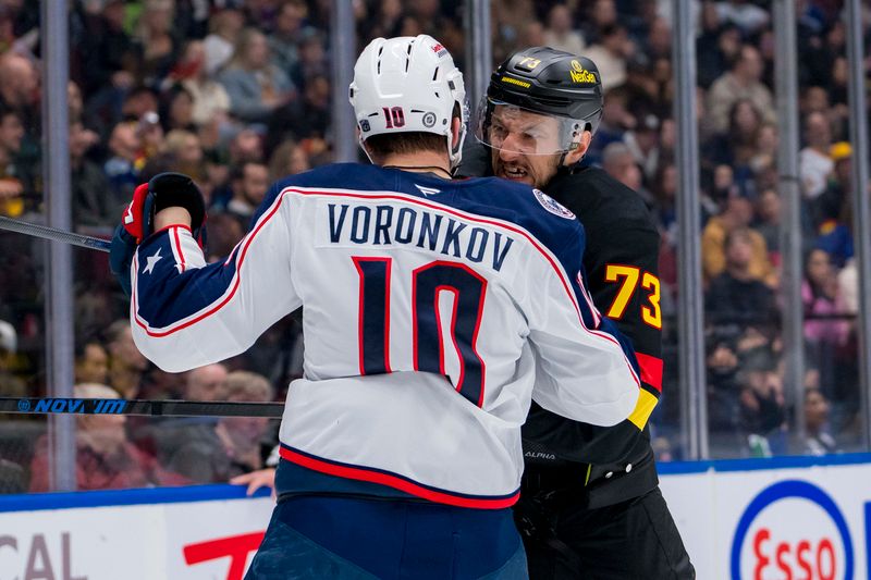 Dec 6, 2024; Vancouver, British Columbia, CAN; Columbus Blue Jackets forward Dmitri Voronkov (10) battles with Vancouver Canucks defenseman Vincent Desharnais (73) during the first period at Rogers Arena. Mandatory Credit: Bob Frid-Imagn Images