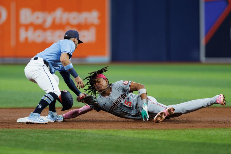 Jun 30, 2024; St. Petersburg, Florida, USA;  Washington Nationals shortstop CJ Abrams (5) steals second base from Tampa Bay Rays shortstop Jose Caballero (7) in the third inning at Tropicana Field. Mandatory Credit: Nathan Ray Seebeck-USA TODAY Sports