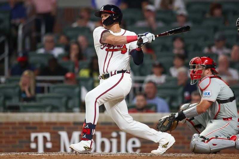 Aug 21, 2024; Atlanta, Georgia, USA; Atlanta Braves third baseman Gio Urshela (9) hits a single against the Philadelphia Phillies in the ninth inning at Truist Park. Mandatory Credit: Brett Davis-USA TODAY Sports
