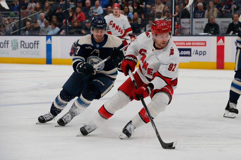 Apr 16, 2024; Columbus, Ohio, USA; Carolina Hurricanes center Evgeny Kuznetsov (92) skates with the puck as Columbus Blue Jackets left wing Johnny Gaudreau (13) trails the play during the third period at Nationwide Arena. Mandatory Credit: Russell LaBounty-USA TODAY Sports