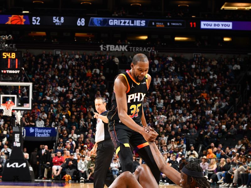 PHOENIX, AZ - FEBRUARY 11:  Bol Bol #11 of the Phoenix Suns is helped to his feet by Kevin Durant #35 during the game against the Memphis Grizzlies on February 11, 2025 at Footprint Center in Phoenix, Arizona. NOTE TO USER: User expressly acknowledges and agrees that, by downloading and or using this photograph, user is consenting to the terms and conditions of the Getty Images License Agreement. Mandatory Copyright Notice: Copyright 2025 NBAE (Photo by Barry Gossage/NBAE via Getty Images)