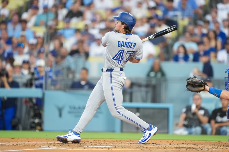 Aug 8, 2025; Los Angeles, California, USA; Toronto Blue Jays pitching coach Pete Walker (41) hits a RBI single during the second inning against the Los Angeles Dodgers at Dodger Stadium. Mandatory Credit: Kirby Lee-Imagn Images
