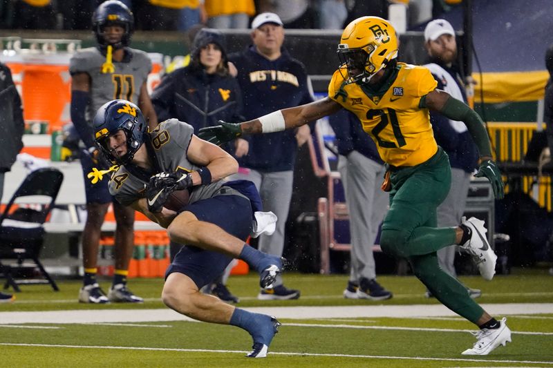 Nov 25, 2023; Waco, Texas, USA; West Virginia Mountaineers wide receiver Hudson Clement (84) makes the catch in front of Baylor Bears cornerback Chateau Reed (21) during the first half at McLane Stadium. Mandatory Credit: Raymond Carlin III-USA TODAY Sports