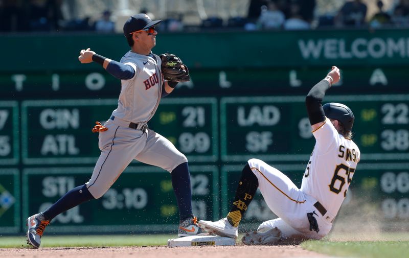 Apr 12, 2023; Pittsburgh, Pennsylvania, USA;  Houston Astros second baseman Mauricio Dubon (14) turns a double play over Pittsburgh Pirates center fielder Jack Suwinski (65) during the fifth inning at PNC Park. Mandatory Credit: Charles LeClaire-USA TODAY Sports