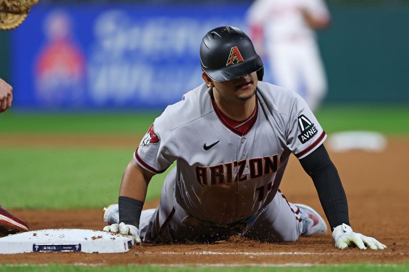 Oct 16, 2023; Philadelphia, Pennsylvania, USA; Arizona Diamondbacks catcher Gabriel Moreno (14) dives back to first base during the seventh inning Philadelphia Phillies in game one of the NLCS for the 2023 MLB playoffs at Citizens Bank Park. Mandatory Credit: Bill Streicher-USA TODAY Sports