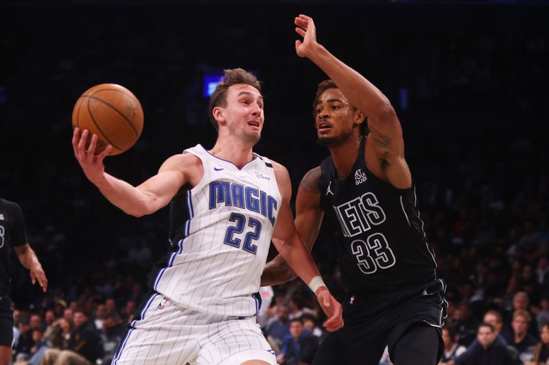 NEW YORK, NEW YORK - NOVEMBER 29: Franz Wagner #22 of the Orlando Magic drives to the basket against Nic Claxton #33 of the Brooklyn Nets during the second half in the Emirates NBA Cup at Barclays Center on November 29, 2024 in New York City. NOTE TO USER: User expressly acknowledges and agrees that, by downloading and or using this Photograph, user is consenting to the terms and conditions of the Getty Images License Agreement. (Photo by Mike Stobe/Getty Images)