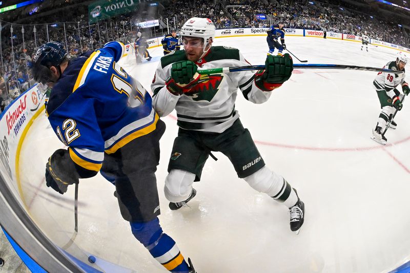 Nov 19, 2024; St. Louis, Missouri, USA;  St. Louis Blues center Radek Faksa (12) and Minnesota Wild center Yakov Trenin (13) battle for the puck during the third period at Enterprise Center. Mandatory Credit: Jeff Curry-Imagn Images