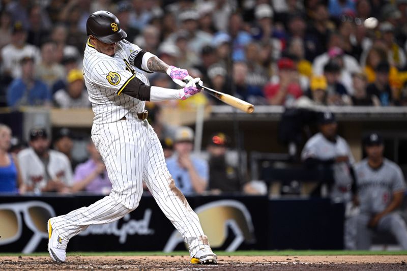 Aug 20, 2024; San Diego, California, USA; San Diego Padres third baseman Manny Machado (13) hits a two-run home run against the Minnesota Twins during the seventh inning at Petco Park. Mandatory Credit: Orlando Ramirez-USA TODAY Sports