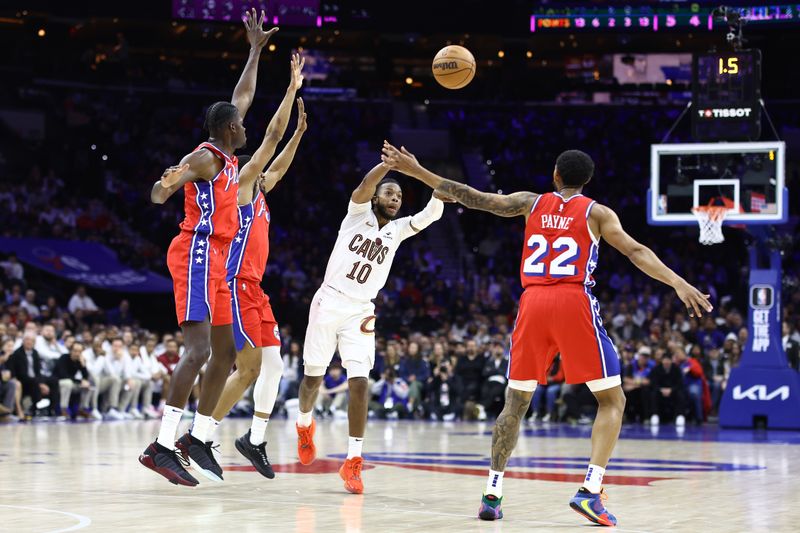 PHILADELPHIA, PENNSYLVANIA - FEBRUARY 23: Darius Garland #10 of the Cleveland Cavaliers passes between Mo Bamba #5, De'Anthony Melton #8 and Cameron Payne #22 of the Philadelphia 76ers during the third quarter at the Wells Fargo Center on February 23, 2024 in Philadelphia, Pennsylvania. (Photo by Tim Nwachukwu/Getty Images)