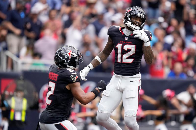 Houston Texans wide receiver Nico Collins (12) celebrates with teammate Robert Woods (2) after catching a 3-yard touchdown pass during the first half of an NFL football game against the Jacksonville Jaguars, Sunday, Sept. 29, 2024, in Houston. (AP Photo/Eric Christian Smith)