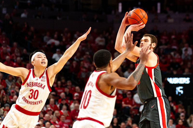 Jan 23, 2024; Lincoln, Nebraska, USA; Ohio State Buckeyes forward Jamison Battle (10) shoots the ball against Nebraska Cornhuskers guard Keisei Tominaga (30) and guard Jamarques Lawrence (10) during the second half at Pinnacle Bank Arena. Mandatory Credit: Dylan Widger-USA TODAY Sports