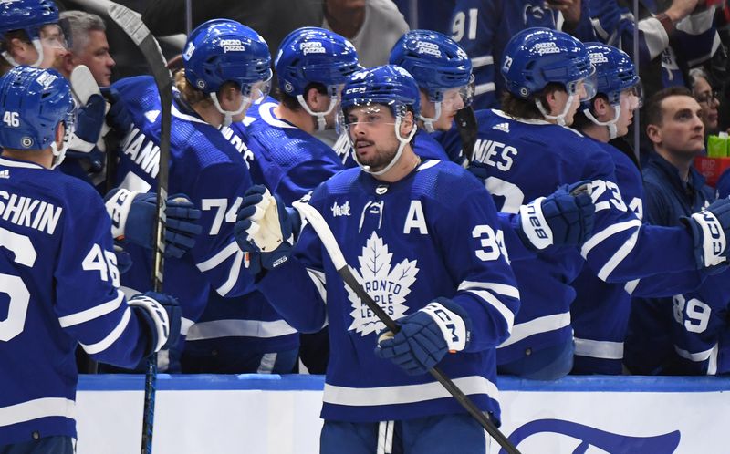 Apr 11, 2024; Toronto, Ontario, CAN; Toronto Maple Leafs forward Auston Matthews (34) celebrates with team mates at the bench after scoring a goal against the New Jersey Devils in the second period at Scotiabank Arena. Mandatory Credit: Dan Hamilton-USA TODAY Sports