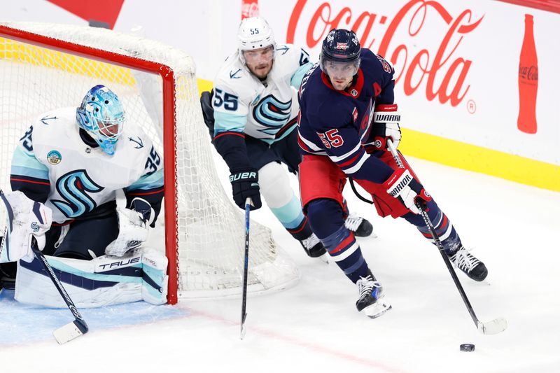 Oct 23, 2025; Winnipeg, Manitoba, CAN; Winnipeg Jets center Mark Scheifele (55) is checked by Seattle Kraken defenseman Ryan Lindgren (55) in the second period at Canada Life Centre. Mandatory Credit: James Carey Lauder-Imagn Images