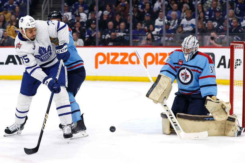 Jan 27, 2024; Winnipeg, Manitoba, CAN; Toronto Maple Leafs right wing Ryan Reaves (75) tries a tip in on Winnipeg Jets goaltender Connor Hellebuyck (37) in the first period at Canada Life Centre. Mandatory Credit: James Carey Lauder-USA TODAY Sports