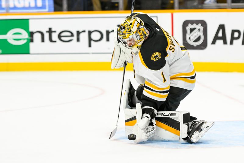 Oct 22, 2024; Nashville, Tennessee, USA;  Boston Bruins goaltender Jeremy Swayman (1) grabs the puck against the Nashville Predators during the first period at Bridgestone Arena. Mandatory Credit: Steve Roberts-Imagn Images