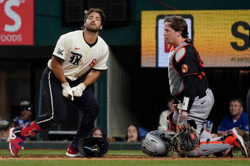 Jul 19, 2024; Arlington, Texas, USA; Texas Rangers third baseman Josh Smith (8)  reacts after being hit by a pitch during the eighth inning as Baltimore Orioles catcher Adley Rutschman (35) looks on at Globe Life Field. Mandatory Credit: Raymond Carlin III-USA TODAY Sports