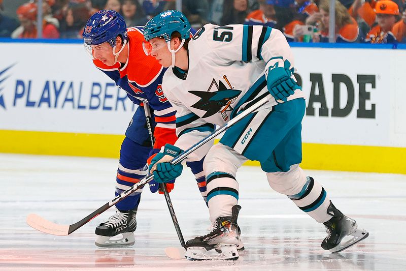 Apr 15, 2024; Edmonton, Alberta, CAN; San Jose Sharks forward Collin Graf (51) and Edmonton Oilers forward Ryan Nugent-Hopkins (93) look for a loose puck during the first period at Rogers Place. Mandatory Credit: Perry Nelson-USA TODAY Sports