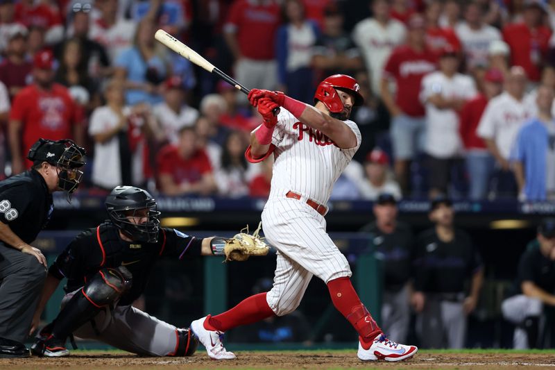 Oct 4, 2023; Philadelphia, Pennsylvania, USA; Philadelphia Phillies left fielder Kyle Schwarber (12) hits a RBI double against the Miami Marlins during the third inning for game two of the Wildcard series for the 2023 MLB playoffs at Citizens Bank Park. Mandatory Credit: Bill Streicher-USA TODAY Sports