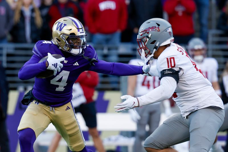 Nov 25, 2023; Seattle, Washington, USA; Washington Huskies wide receiver Germie Bernard (4) breaks a tackle attempt by Washington State Cougars defensive end Ron Stone Jr. (10) during the first quarter at Alaska Airlines Field at Husky Stadium. Mandatory Credit: Joe Nicholson-USA TODAY Sports