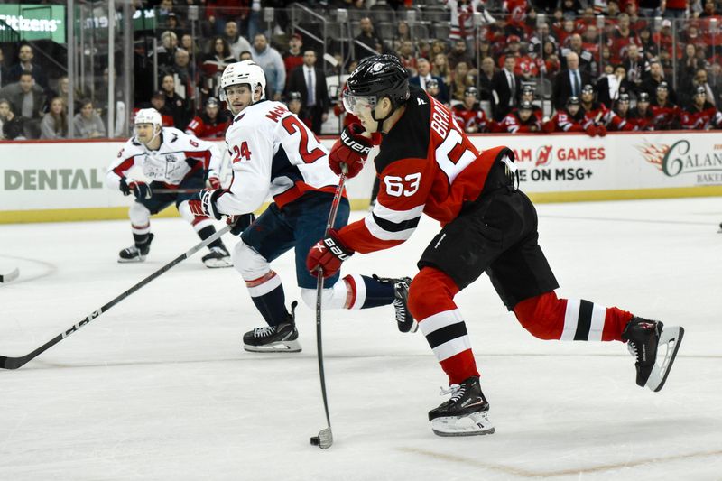 Oct 19, 2024; Newark, New Jersey, USA; New Jersey Devils left wing Jesper Bratt (63) shoots the puck as Washington Capitals center Connor McMichael (24) defends during the overtime period at Prudential Center. Mandatory Credit: John Jones-Imagn Images