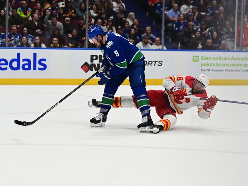 Mar 23, 2024; Vancouver, British Columbia, CAN; Vancouver Canucks forward J.T. Miller (9) skates with puck against the Calgary Flames defenseman Olivver Kylington (58) during the third period at Rogers Arena. Mandatory Credit: Simon Fearn-USA TODAY Sports