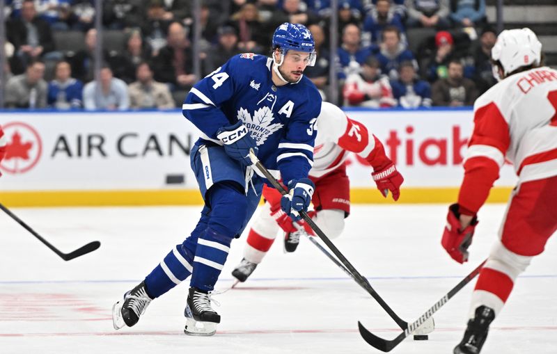 Jan 14, 2024; Toronto, Ontario, CAN;  Toronto Maple Leafs forward Auston Matthews (34) carries the puck up ice against the Detroit Red Wings in the third period at Scotiabank Arena. Mandatory Credit: Dan Hamilton-USA TODAY Sports