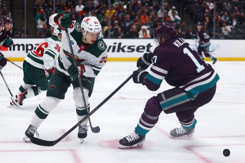 Mar 19, 2024; Anaheim, California, USA; Minnesota Wild center Marco Rossi (23) passes the puck through the legs of Anaheim Ducks left wing Alex Killorn (17) during the second period ofna game at Honda Center. Mandatory Credit: Jessica Alcheh-USA TODAY Sports